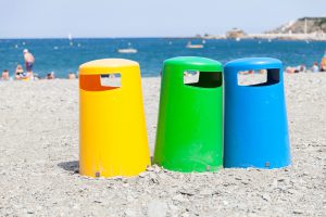 Des poubelles colorées pour séparer les déchets sur une plage du sud de la France